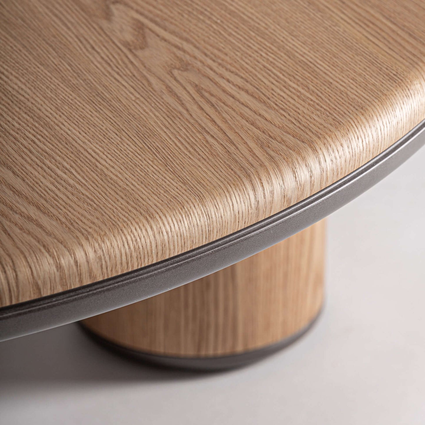 Primer plano de la mesa de centro LENEO de DM marrón claro y madera marrón (100×100×35 cm) con superficie redonda texturada y base cilíndrica, fotografiada sobre un fondo liso.