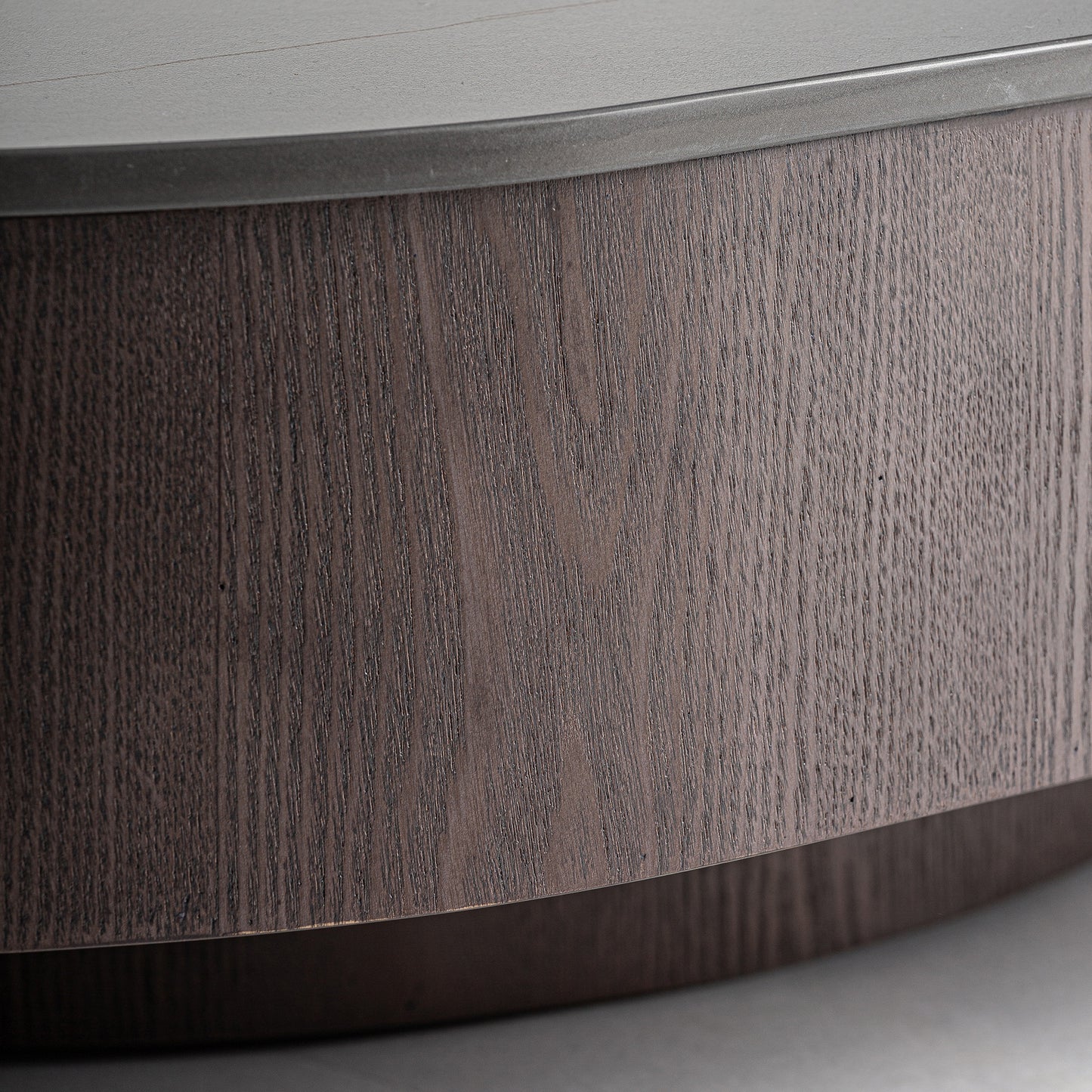 Primer plano de la Mesa de centro en mármol sintético negro y madera de nogal (70×70×35 cm), en el que destaca su madera de nogal curvada y su superficie lisa y contemporánea, perfecta para espacios modernos.