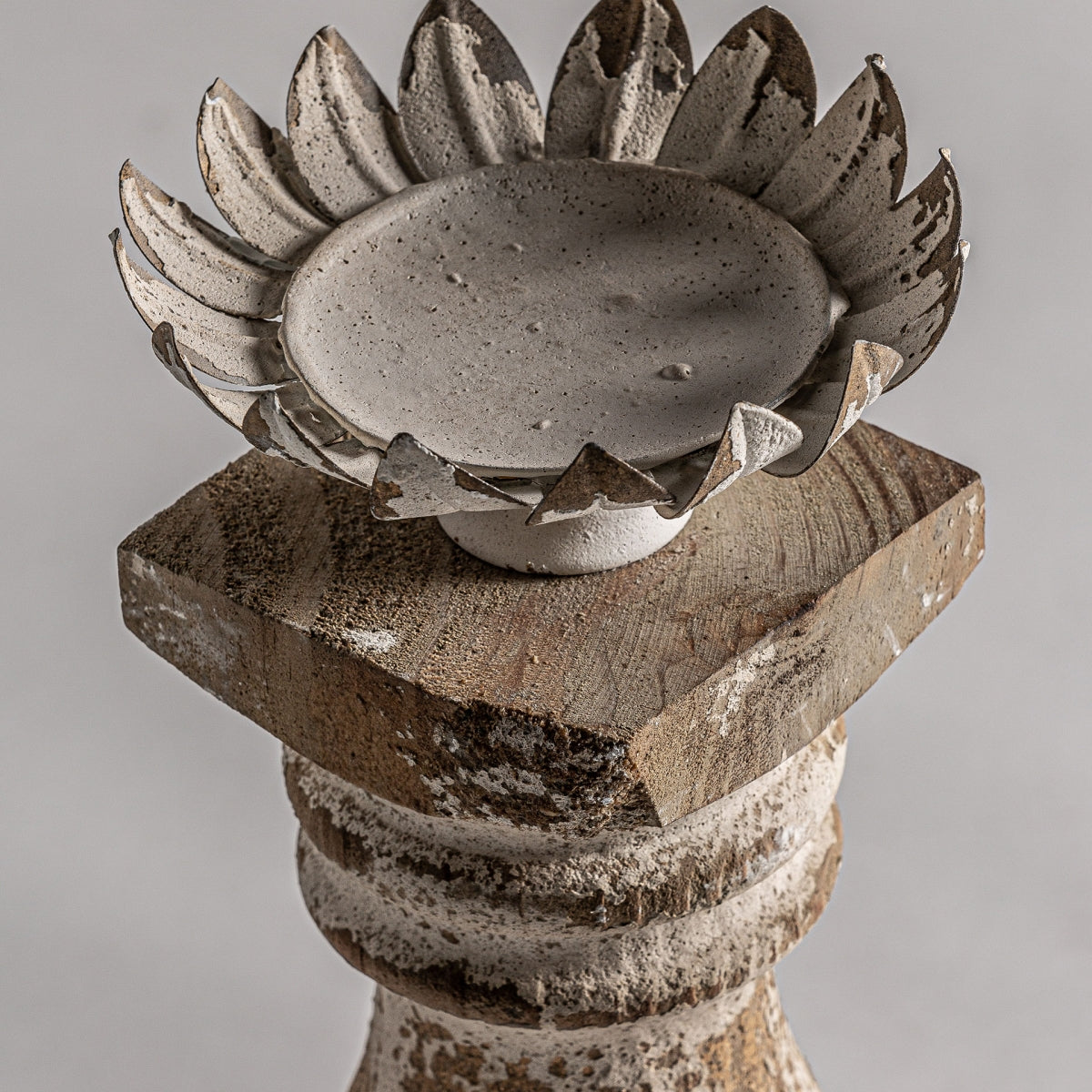 El portavelas de hierro y madera Abert se asienta elegantemente sobre un pedestal de madera desgastada, con un diseño que evoca una decoración clásica. Perfecto para quienes aprecian el estilo colonial, combina a la perfección con cualquier fondo neutro.