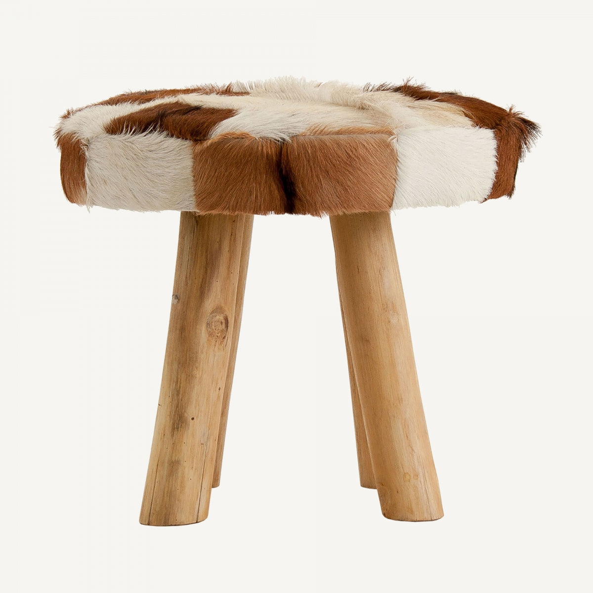 Presentamos el Taburete bajo en madera de pino y piel Dallas: un taburete redondo con cojín de piel de vacuno patchwork y tres patas cilíndricas de madera, que luce un estilo de diseño nórdico.