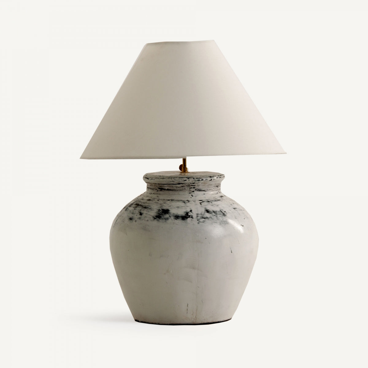 La lámpara de sobremesa en terracota acabado envejecido Lema tiene base ancha y redondeada y pantalla blanca cónica, ideal para dar estilo shabby chic a tu espacio.