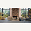 Amplio salón con grandes ventanales, sofás beige, sillones, chimenea de mármol, estanterías, decoración moderna y un toque vintage que aporta la alfombra clásica en viscosa (340x240 cm) Keisi, con vistas a un paisaje boscoso.