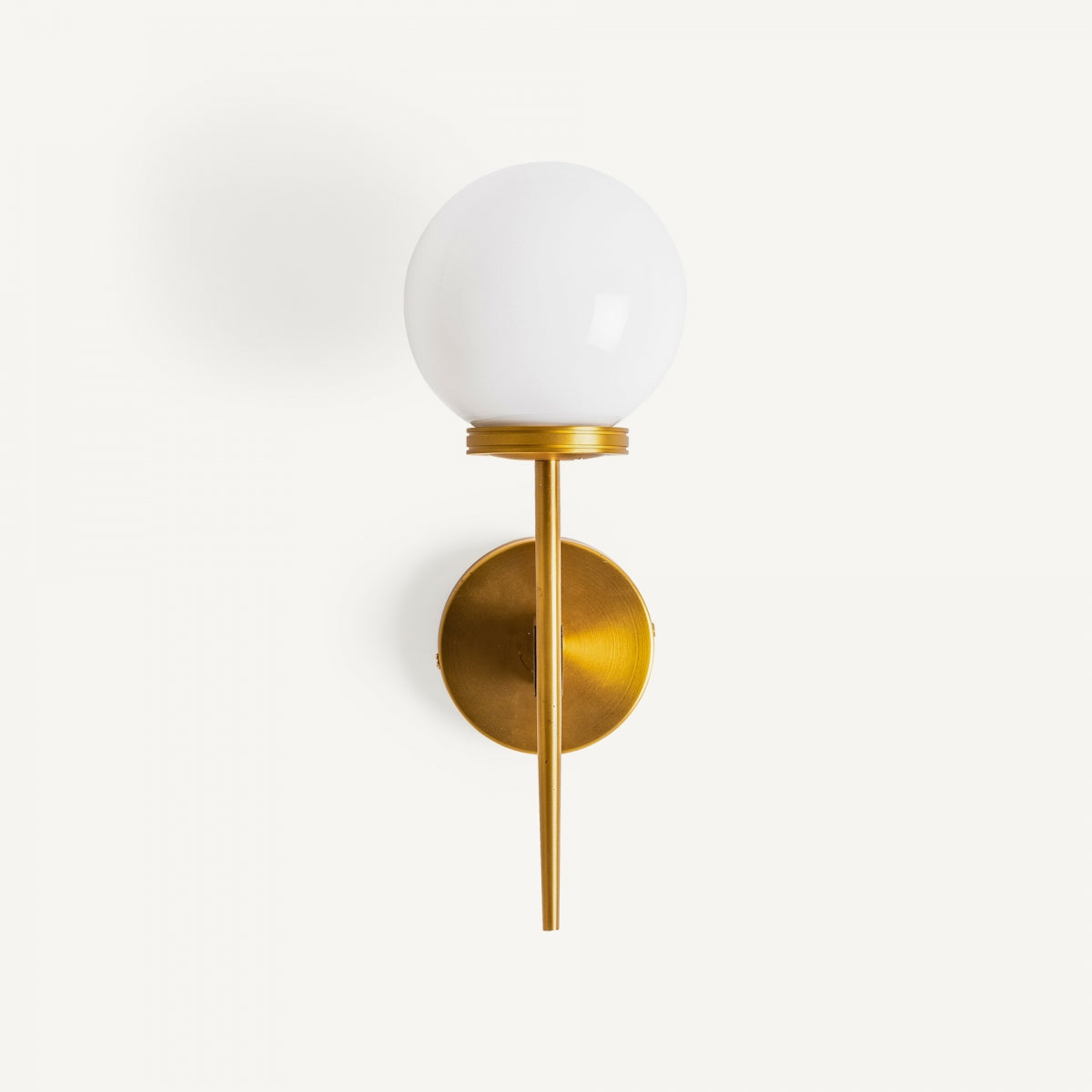 El aplique de pared en latón dorado y cristal opalino Bolar presenta un globo redondo de vidrio opalino y una elegante base de latón dorado, montado elegantemente en una pared blanca sencilla.