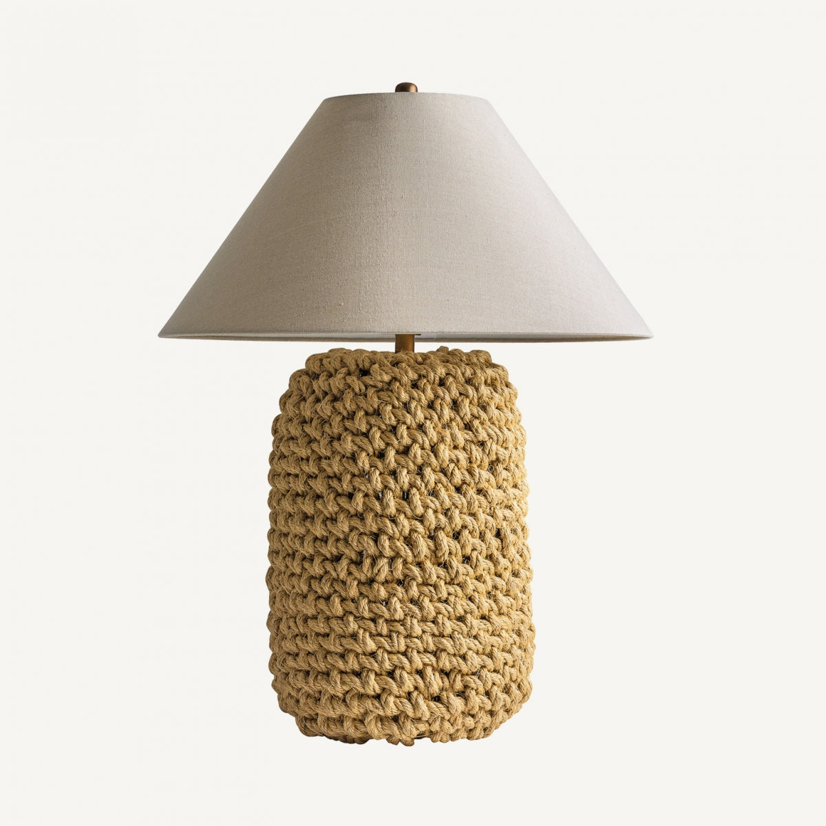 La Lámpara de sobremesa en cuerda y lino Rugge, con pantalla beige y base de cuerda natural, aporta elegancia y calidez a cualquier espacio con su suave iluminación sobre un fondo blanco.