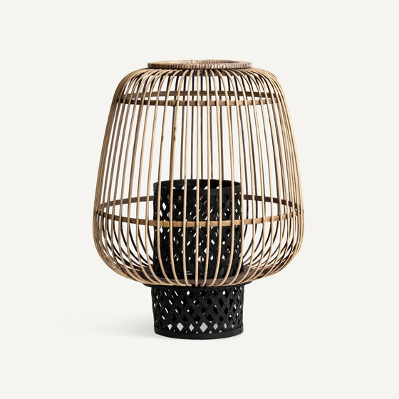 El portavelas moderno de bambú y ratán Ghiare presenta una base cilíndrica negra con un patrón enrejado, agregando un toque de diseño contemporáneo sobre un fondo blanco liso.