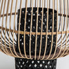 Este primer plano muestra el Portavelas moderno de bambú y ratán Ghiare, que presenta una cesta negra tejida dentro de una estructura de madera calada. Sus líneas elegantes y tonos cálidos realzan cualquier decoración cálida, representando un estilo contemporáneo.