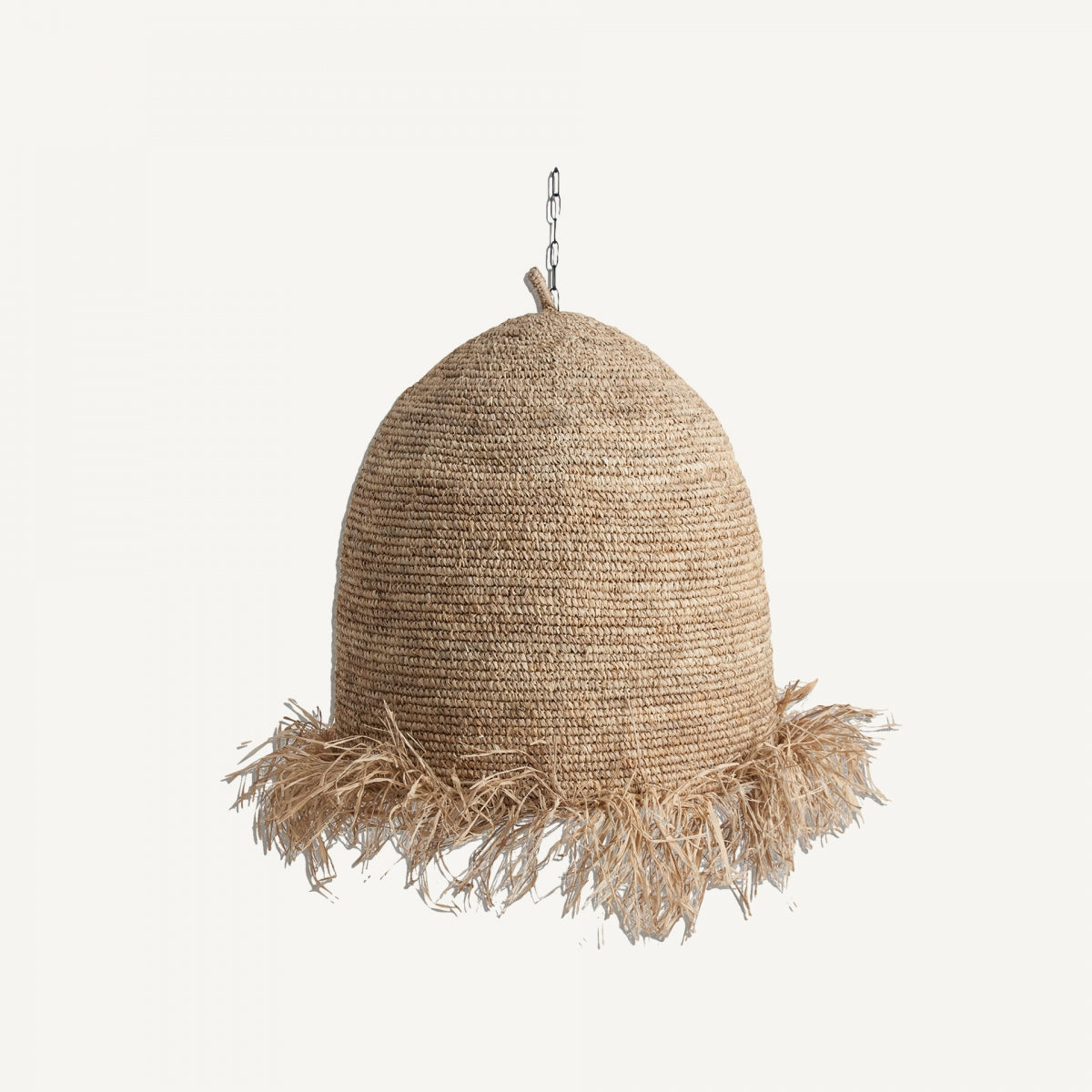 La lámpara colgante en fibra natural Tresa, de forma de cúpula y diseño tejido con fleco en el borde inferior, cuelga de una pequeña cadena metálica, ideal para añadir un toque contemporáneo.