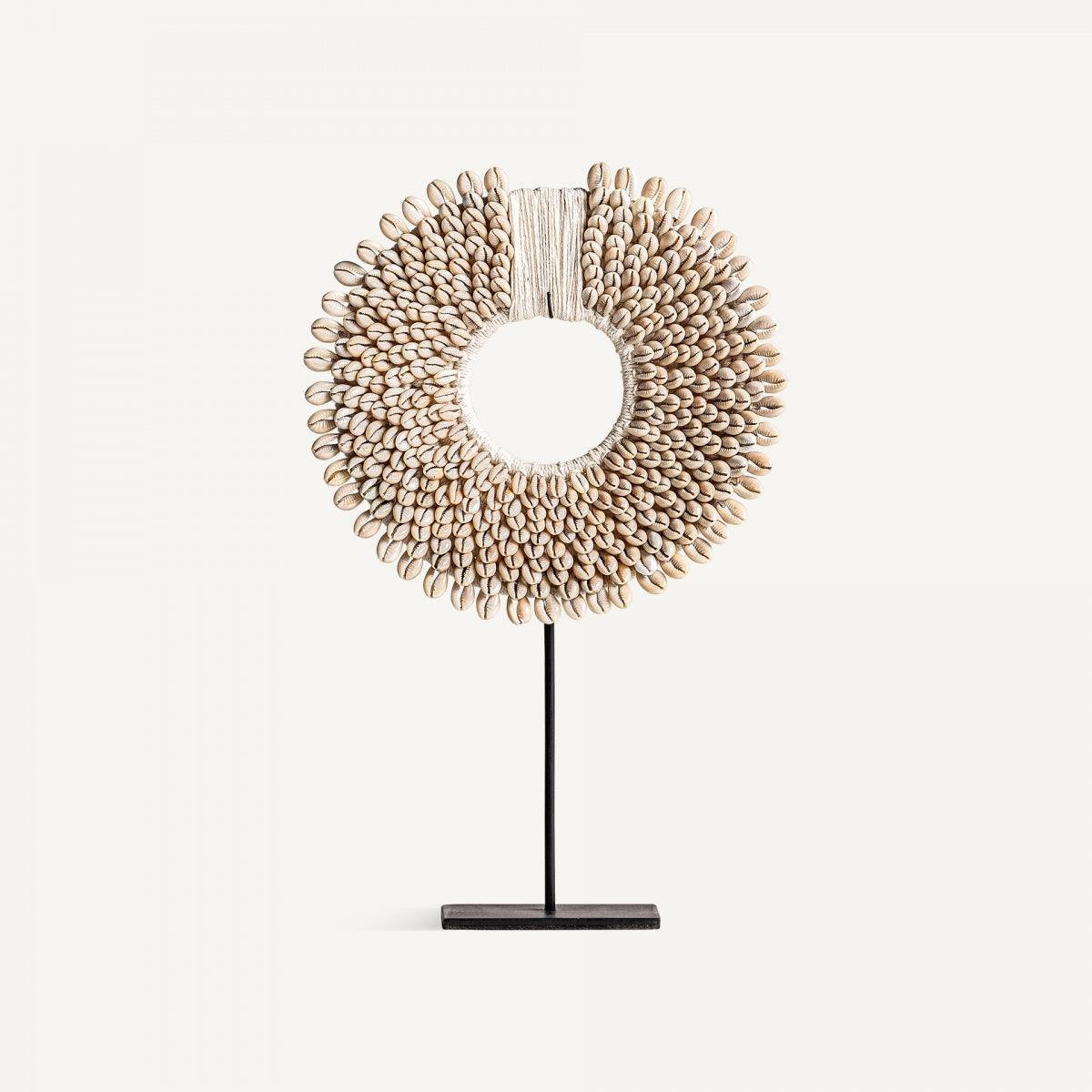 La Figura decorativa en hierro y conchas Etnica es circular, hecha con caracoles unidos y montada sobre base negra—ideal para aportar un toque étnico y artístico a tu hogar.