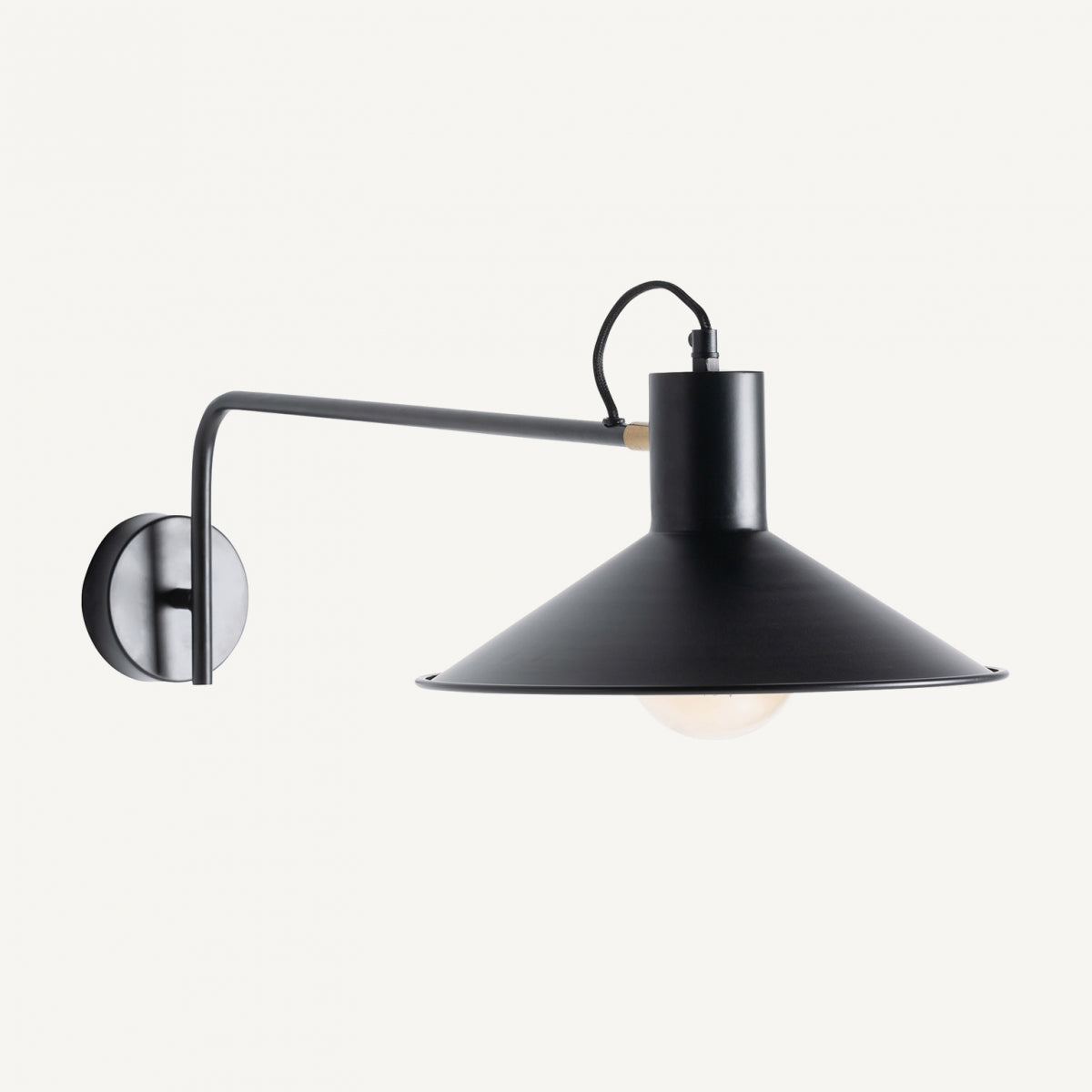 Aplique de pared en hierro negro y latón Aseud con pantalla cónica amplia y bombilla expuesta, que resalta su diseño contemporáneo sobre fondo blanco.