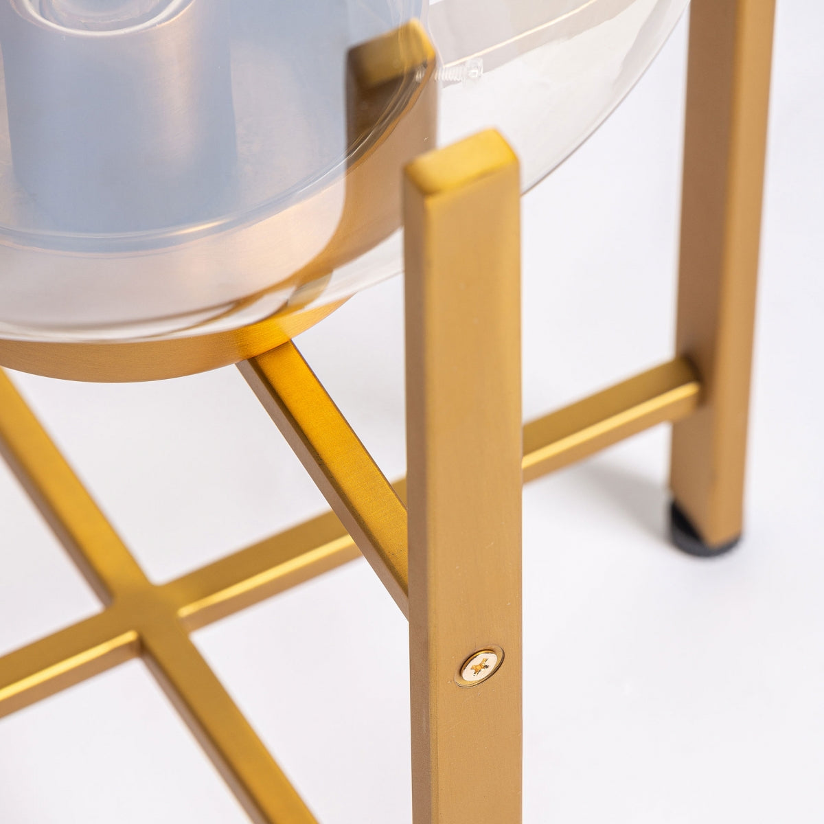 Primer plano de la Lámpara de mesa en latón y cristal Aurea, que presenta un soporte de metal dorado con una pantalla de cristal redonda y transparente, ideal para decoración interior moderna o fanáticos del diseño art deco.