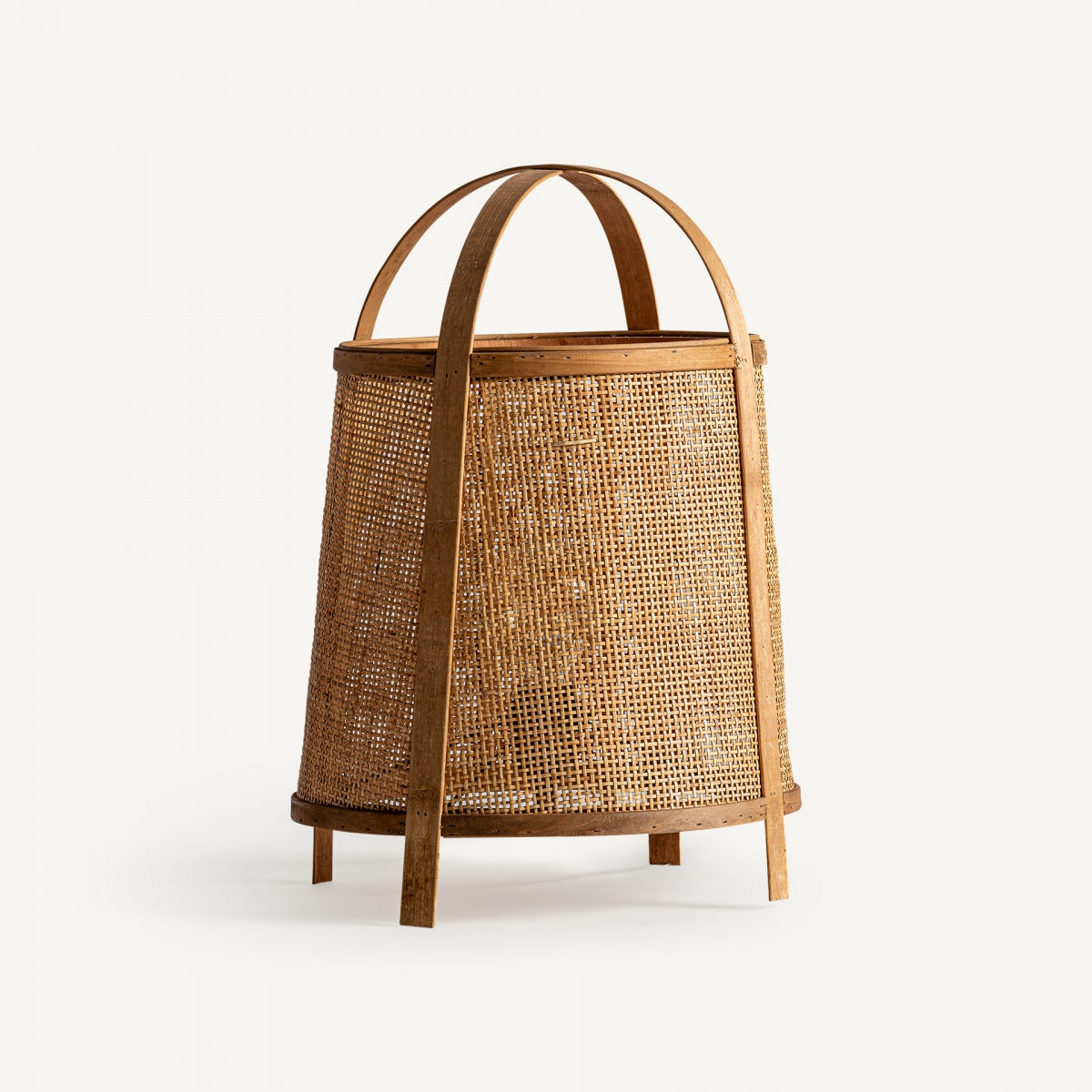 La lámpara de sobremesa en ratán KIRI destaca por su elegante entramado de ratán y diseño cómodo, con base redonda, cuatro patas de madera y dos asas curvas que aportan funcionalidad y estilo.