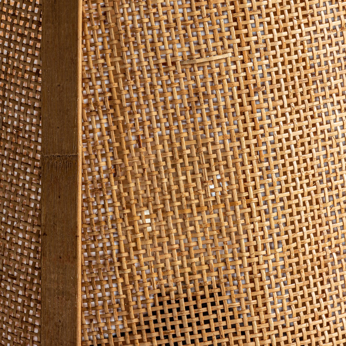 Primer plano de la Lámpara de sobremesa en ratán KIRI mostrando su marco de madera a la izquierda y algunos pequeños huecos en el tejido de ratán, resaltando su diseño sofisticado.