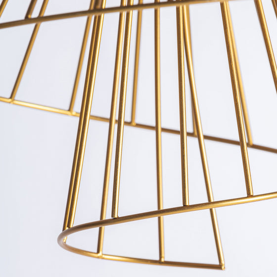 Primer plano de la Lámpara colgante de hierro dorado Stowe A, que presenta un moderno diseño geométrico con elegantes líneas de alambre con acabado dorado sobre un fondo blanco liso.