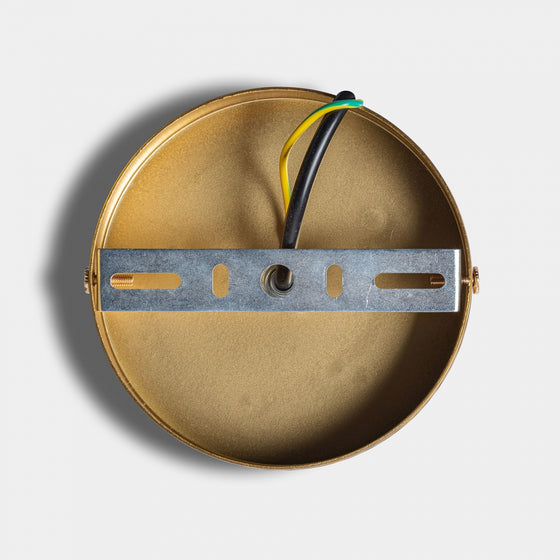 La base redonda metálica con soporte de montaje y cables negro, blanco y amarillo-verde es ideal para la Lámpara colgante en hierro dorado Stowe A de diseño geométrico, mostrada sobre fondo blanco.
