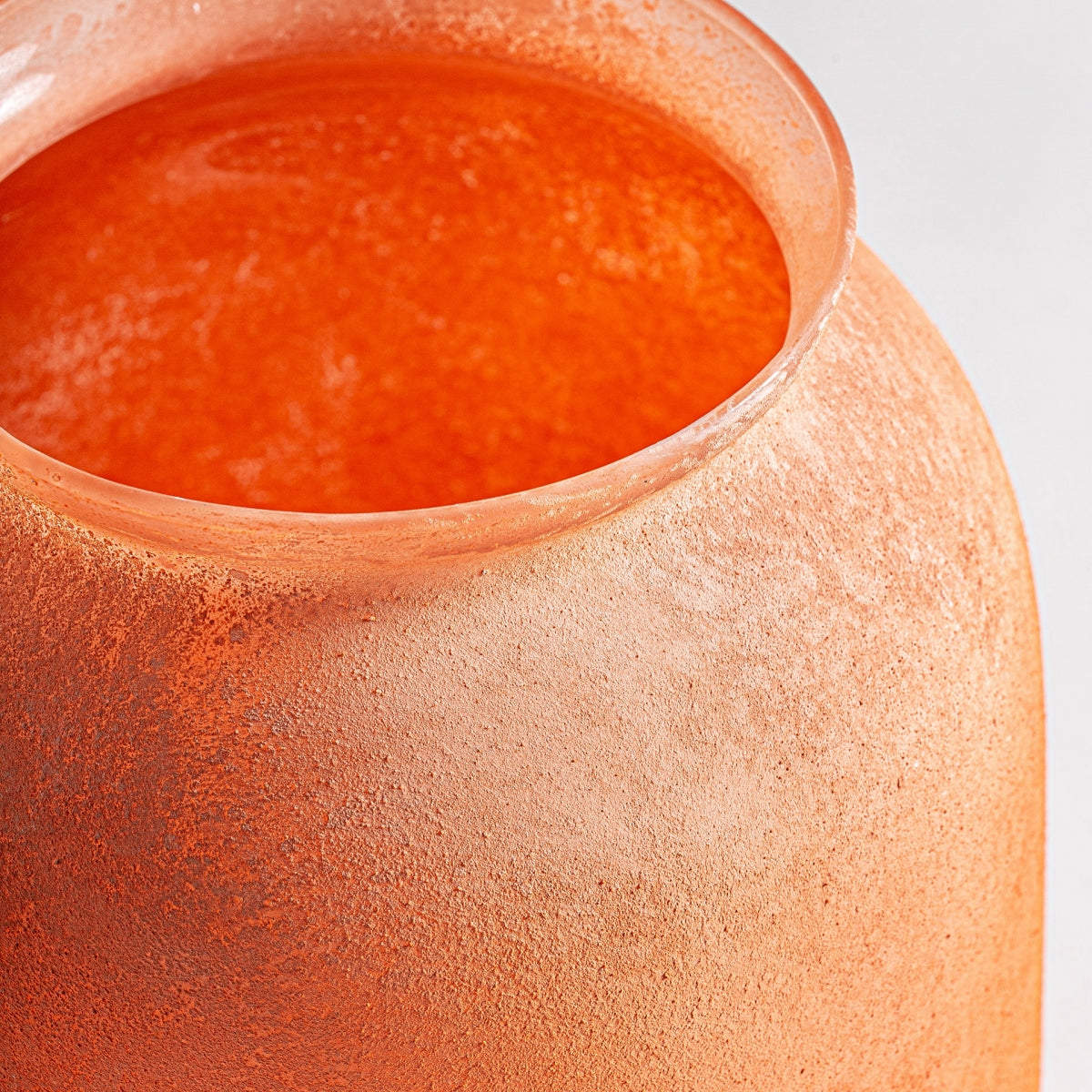Primer plano del Jarrón de vidrio vintage Den, un jarrón de color naranja texturizado y amplia apertura, ideal para decoración de interiores, sobre un fondo liso y claro.