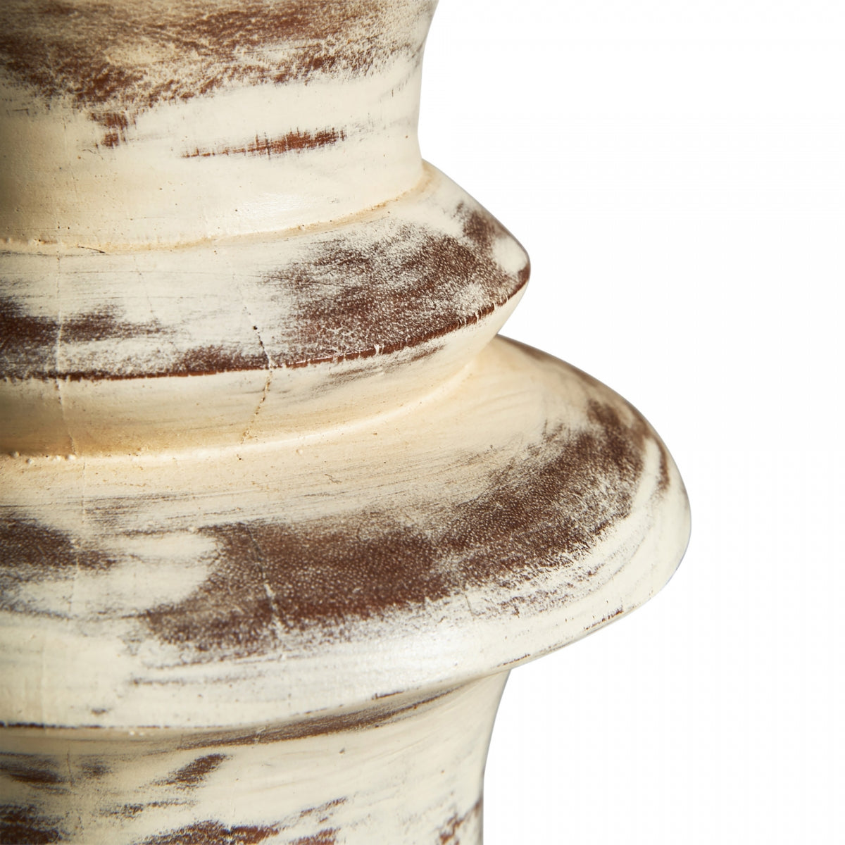 Primer plano de una superficie de madera texturizada y desgastada con crestas circulares y pintura marrón blanquecina, que captura el encanto vintage perfecto para complementar la Lámpara de mesa en madera de mango y algodón Livia.