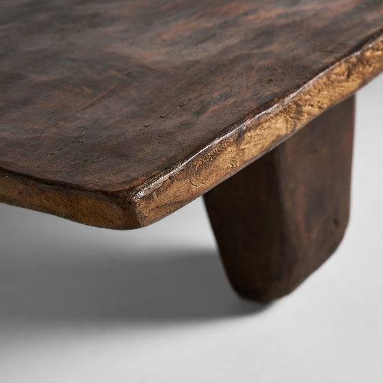 Primer plano de una Mesa de Centro Rectangular en Madera de Teka Erara, mostrando su rica textura de grano y su robusta pata sobre un fondo neutro.