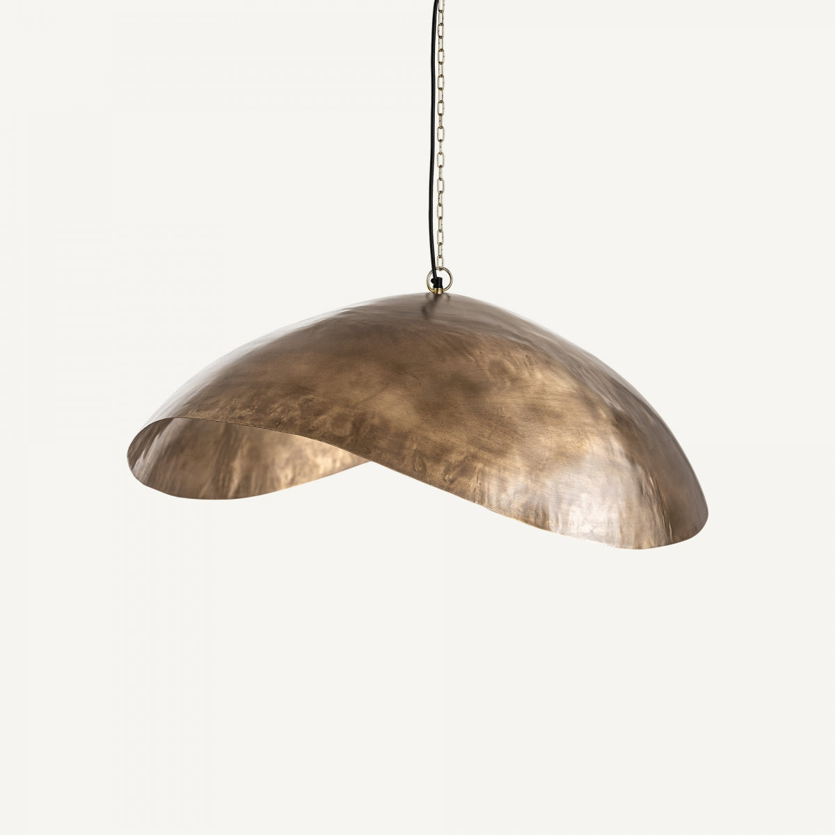 La lámpara colgante en hierro dorado Ardec, con pantalla asimétrica en forma de cúpula y suspendida por una cadena sobre fondo blanco, aporta un toque sutil de diseño art déco.