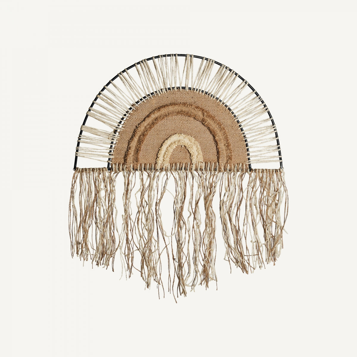 El Panel decorativo de yute y hierro Mientras, con forma semicircular, fibras naturales en capas y flecos largos, es ideal para añadir un toque bohemio a tu espacio.