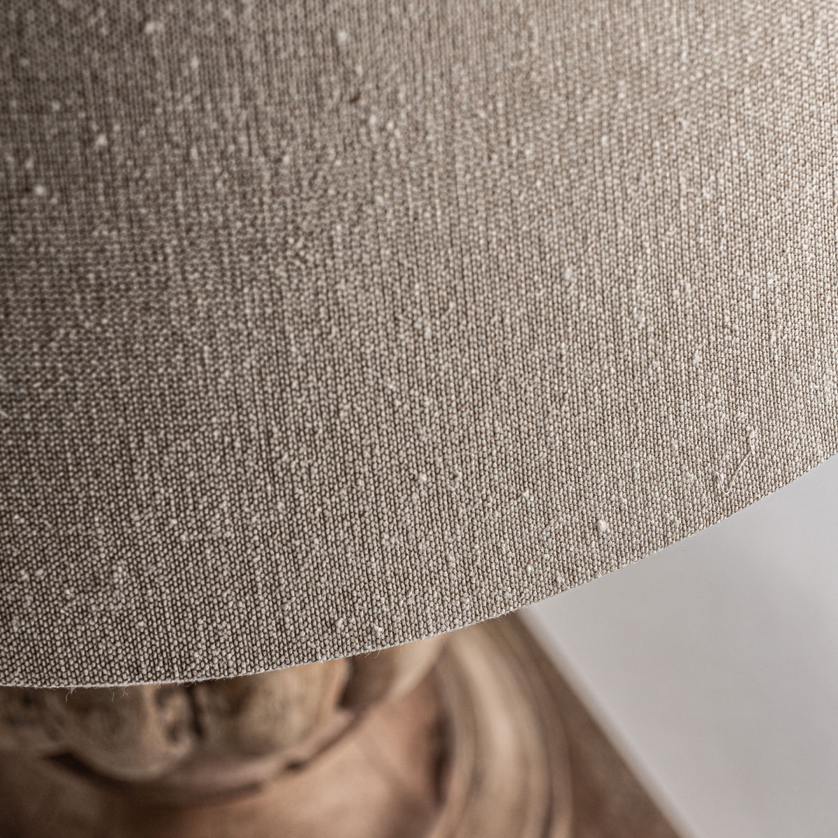 Primer plano de la Lámpara de sobremesa en madera de mango Nines, con una pantalla de tela texturizada beige sobre una base de madera de mango, ideal para decoración rústica o como elegante lámpara de sobremesa.