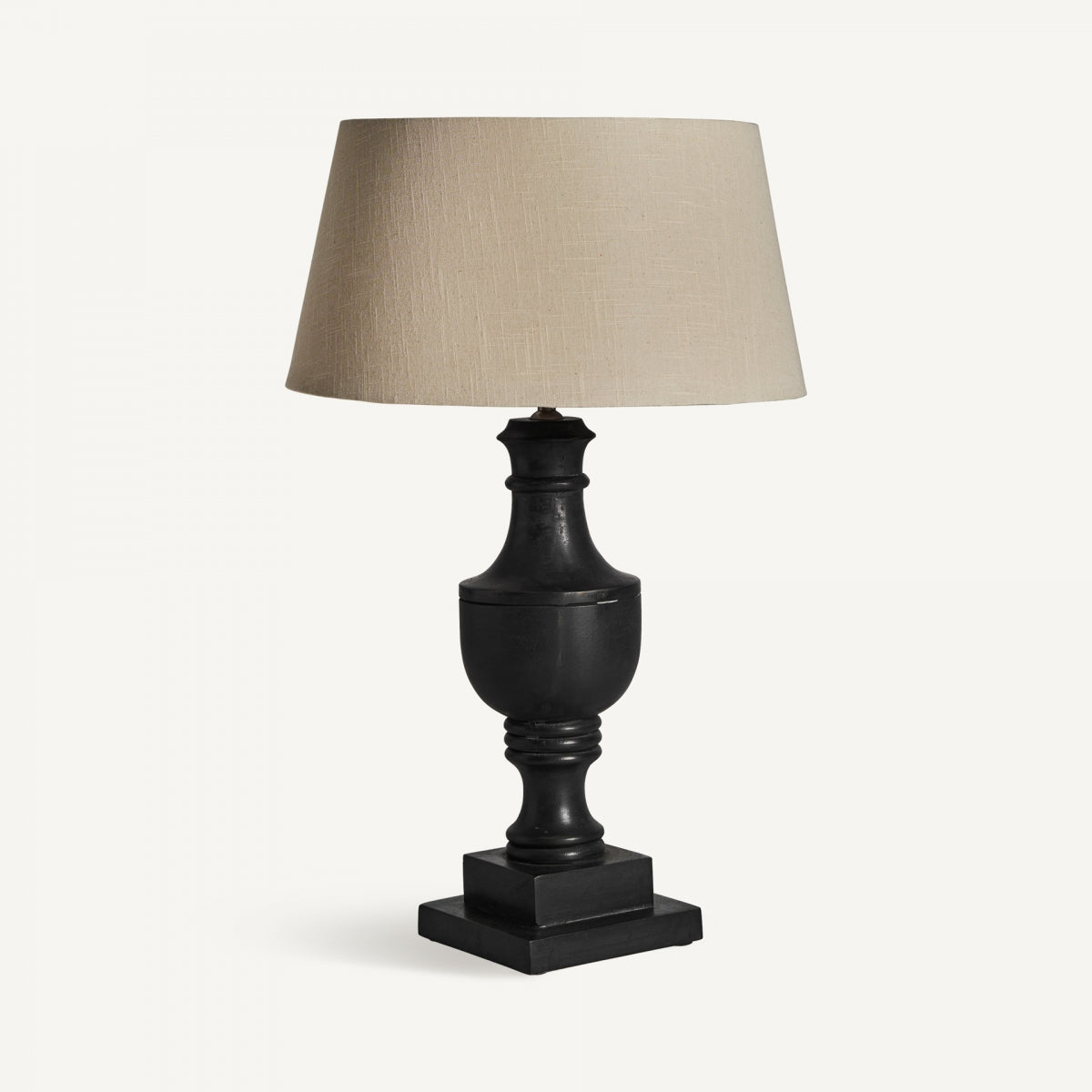 La lámpara de mesa en madera de mango y algodón Provence presenta un acabado negro, una base cuadrada de madera de mango y una pantalla de algodón beige, sobre un fondo blanco liso.
