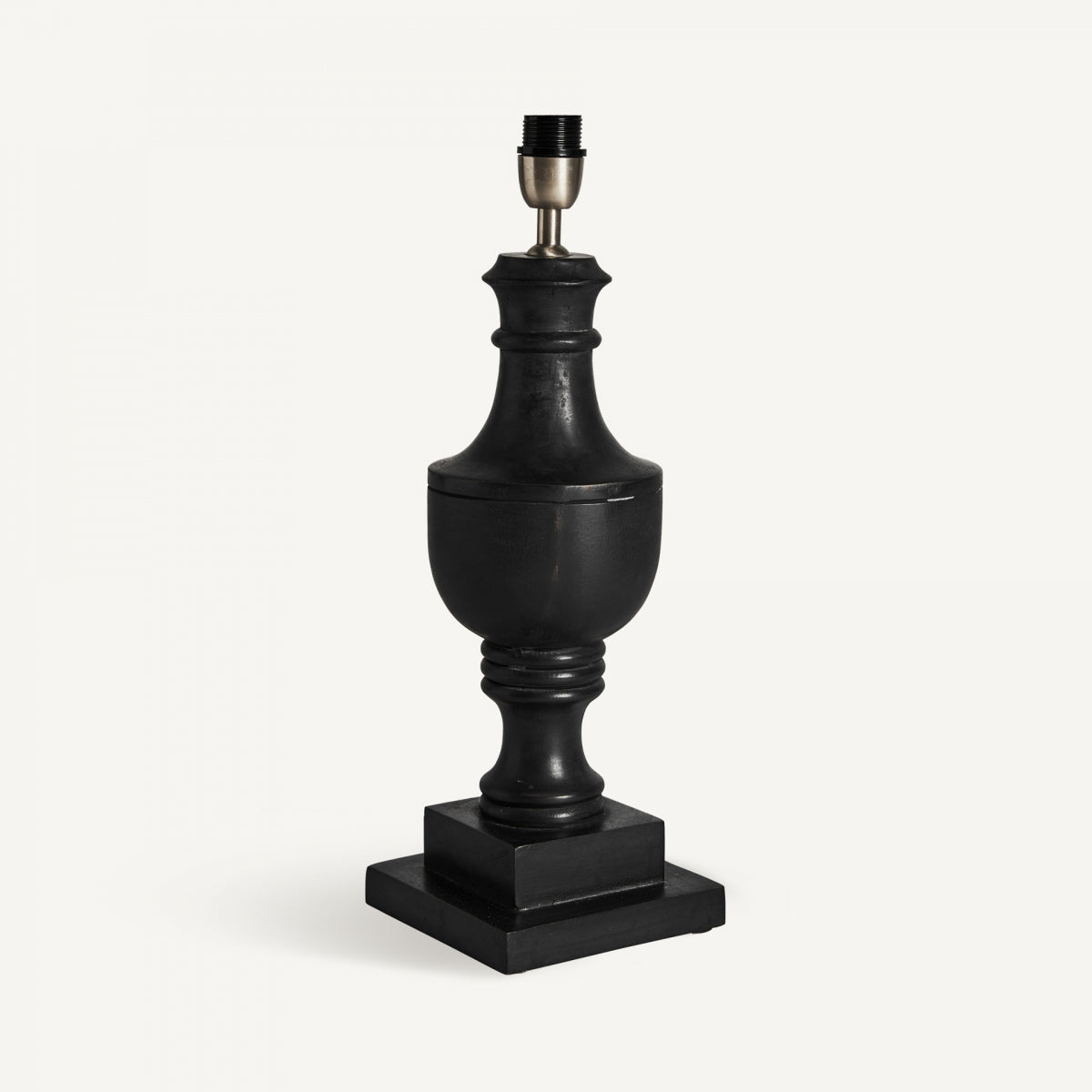 La lámpara de mesa en madera de mango y algodón Provence presenta una base negra clásica en forma de urna sobre un pedestal cuadrado de madera de mango y un casquillo metálico, sobre un fondo blanco liso para un elegante estilo provenzal.