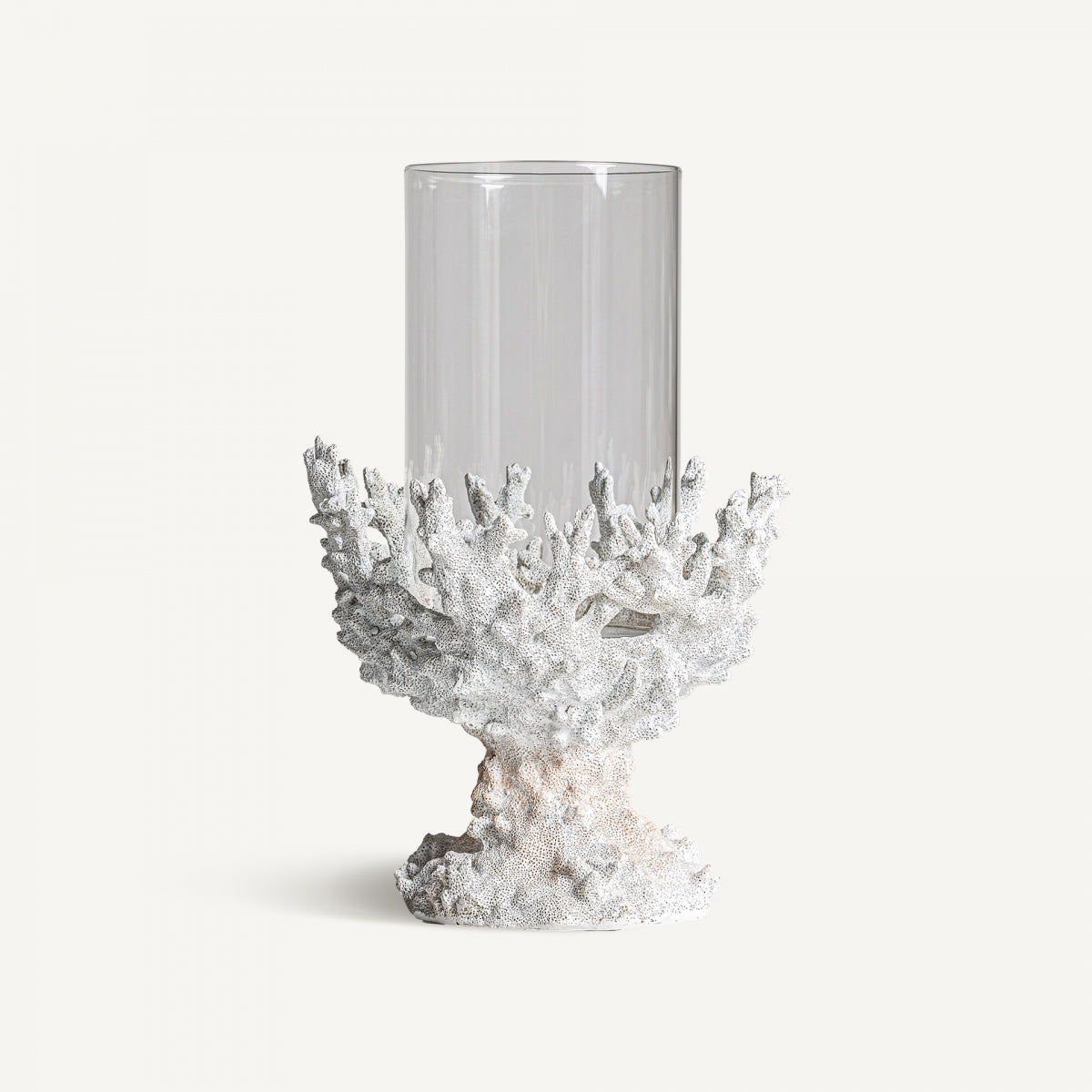 El Portavelas en resina blanca Arrecife G presenta un jarrón de vidrio transparente sobre una base texturizada en forma de coral blanco, que irradia una decoración elegante con estilo nórdico sobre un fondo blanco prístino.
