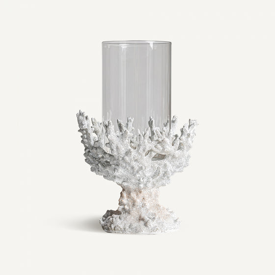 El Portavelas en resina blanca Arrecife G presenta un jarrón de vidrio transparente sobre una base texturizada en forma de coral blanco, que irradia una decoración elegante con estilo nórdico sobre un fondo blanco prístino.