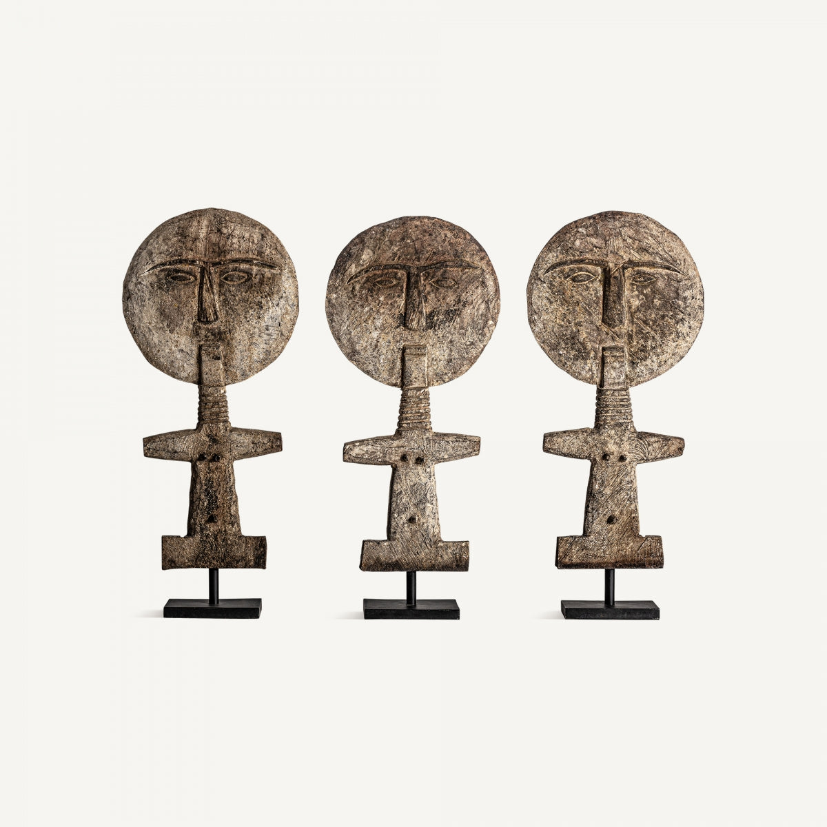 La Figura decorativa en madera tropical Palma presenta tres esculturas abstractas con cabezas circulares y cuerpos estilizados sobre bases negras, evocando un diseño étnico ideal para espacios modernos.