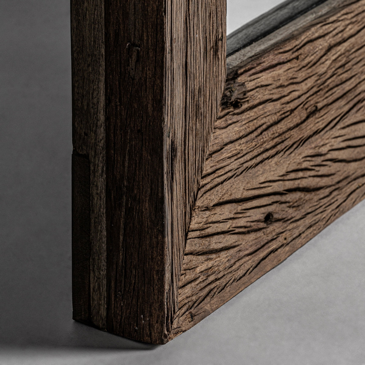 Primer plano de la esquina del Espejo de madera recuperada estilo étnico (90x210 cm) Samsun S, resaltando su veta visible de la madera y su textura rústica, sobre un fondo liso.