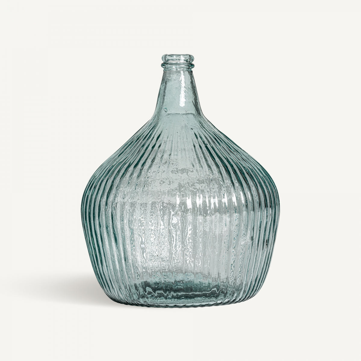 Jarrón en vidrio reciclado Sumaya A: botella de vidrio reciclado con cuerpo redondeado, cuello angosto y textura vertical sutil, ideal para decoración del hogar. Presentada sobre fondo blanco.