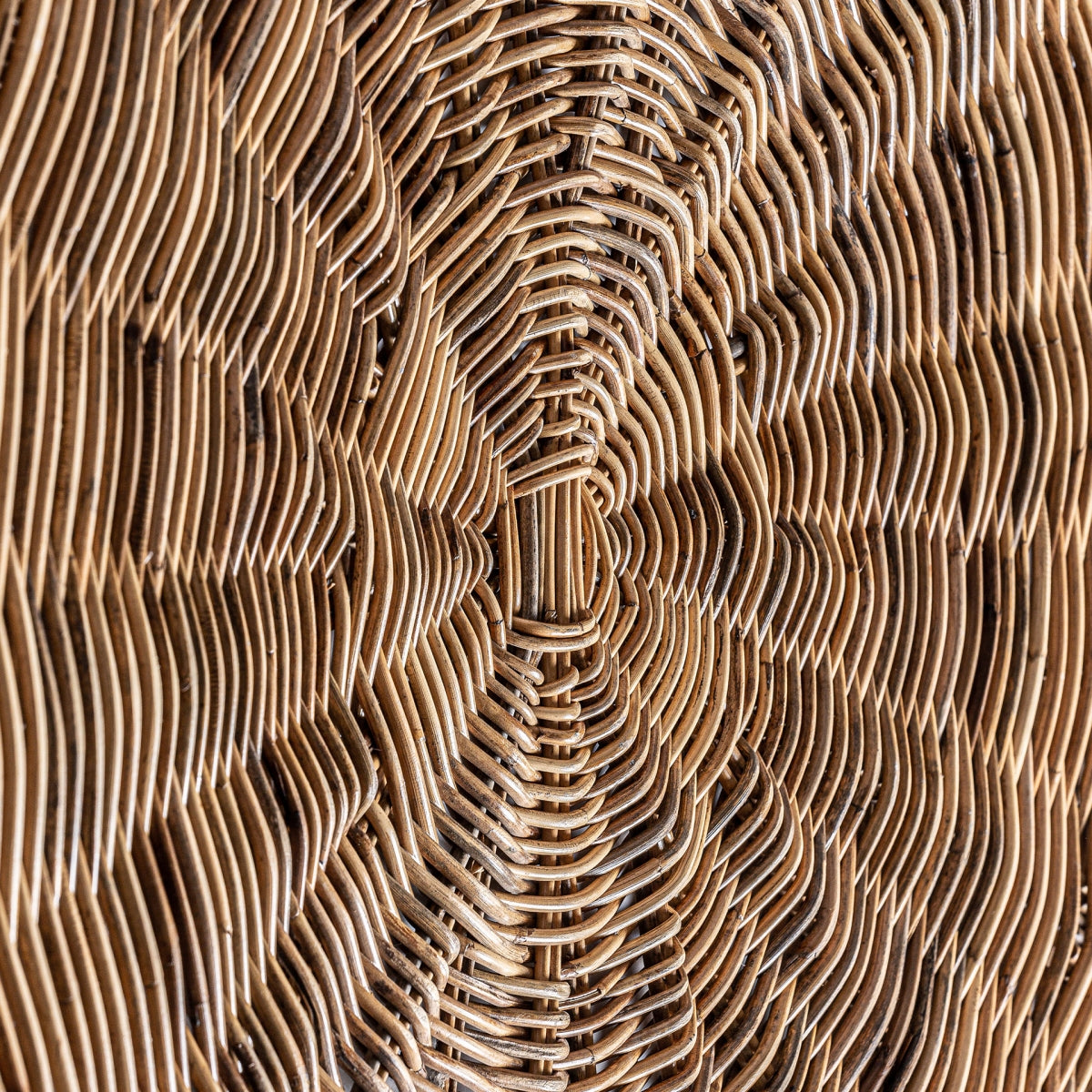 Primer plano del Panel decorativo en ratán bohemio Aranda, que presenta un patrón tejido concéntrico intrincado y capas texturizadas, ideal para agregar estilo boho a cualquier espacio.