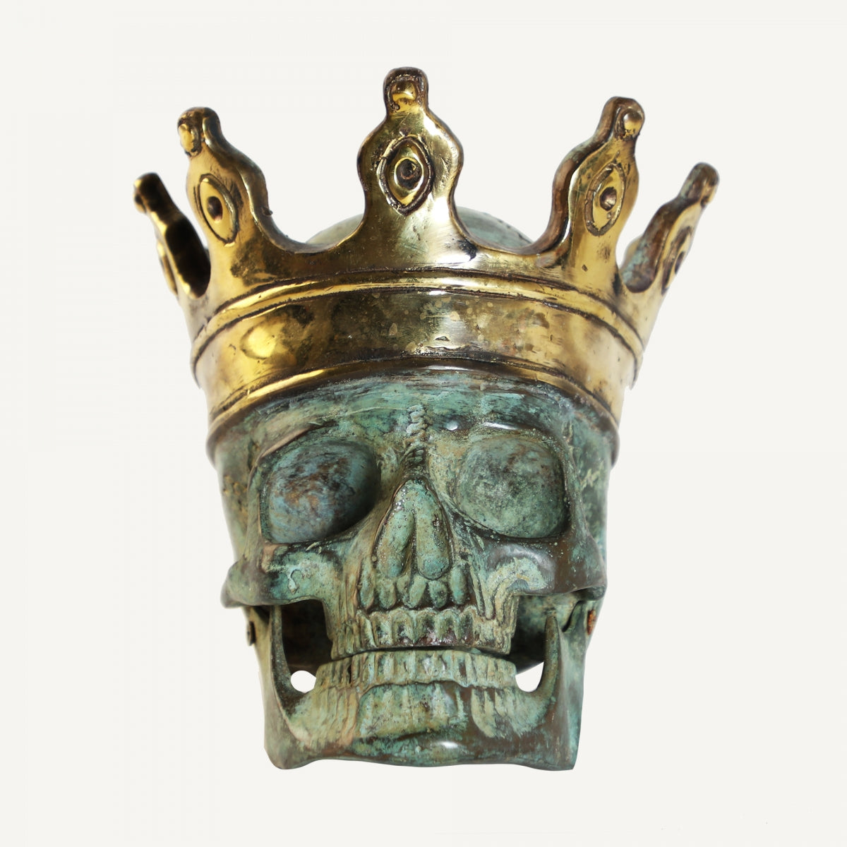 La Figura decorativa en bronce verde Calavera de alta calidad, con corona dorada, se presenta sobre un fondo blanco.