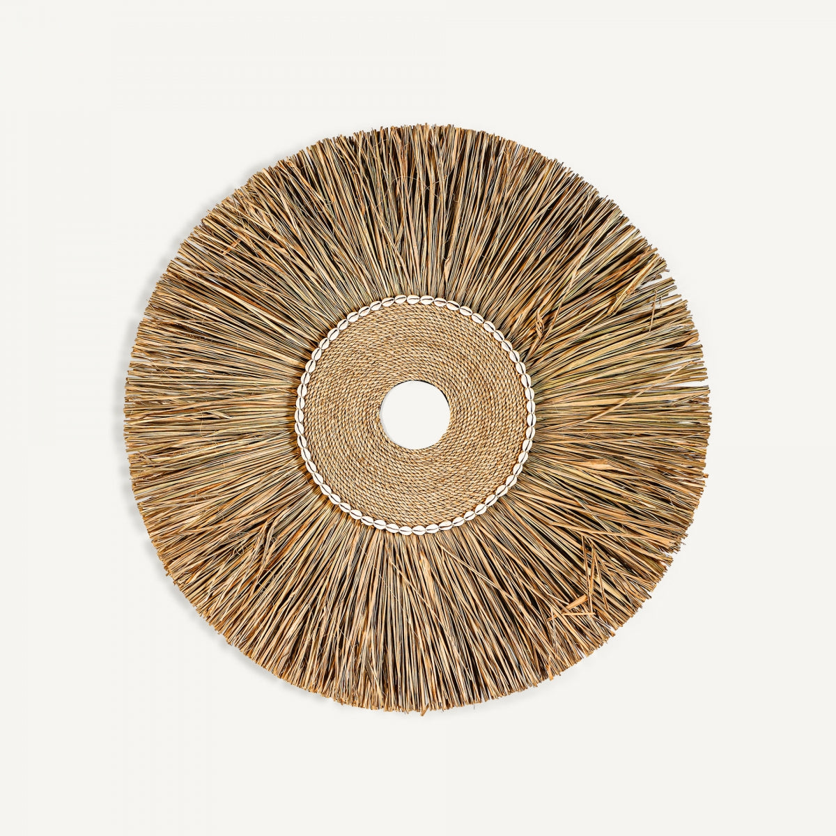 El Panel decorativo en rafia marrón Boho está hecho de rafia natural con un aro tejido central y una fila de pequeñas conchas blancas; ideal para dar un toque bohemio a tu espacio.