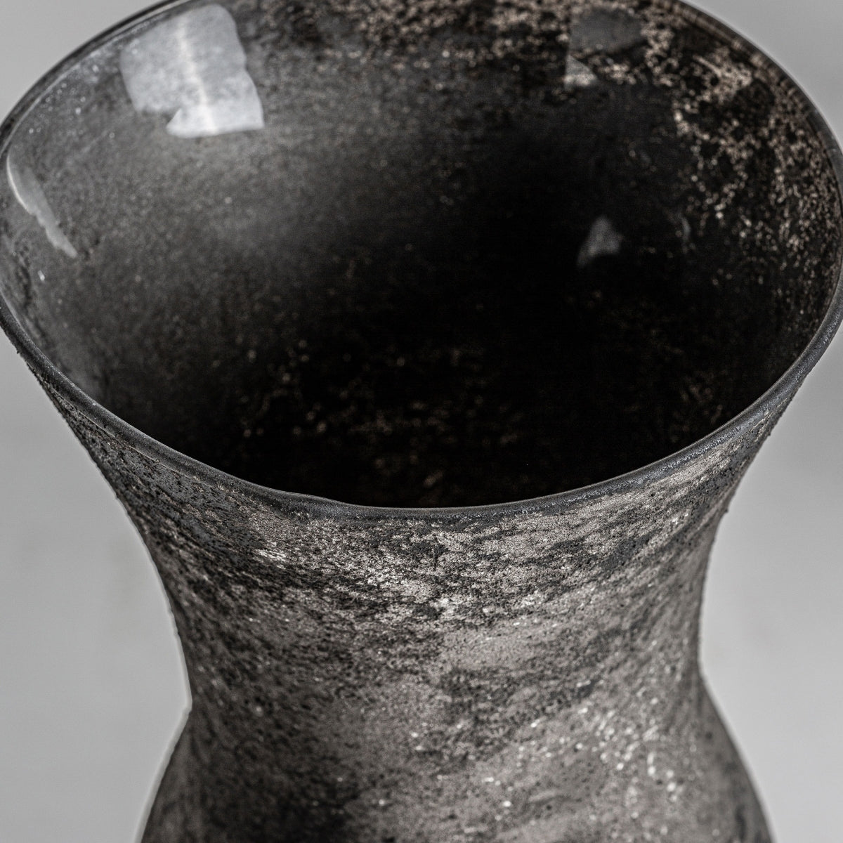 Vista de primer plano de la parte superior del Jarrón en vidrio negro envejecido Blaj S, un jarrón de vidrio oscuro texturizado con una abertura amplia y acampanada, perfecto para la decoración contemporánea.