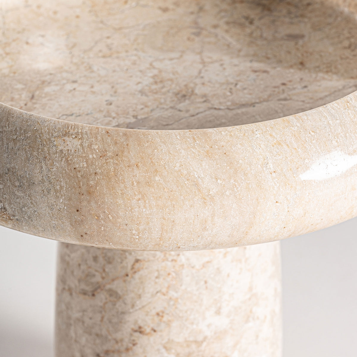 Primer plano de la figura decorativa en mármol marfil de Cowe, que presenta mármol beige con jaspeado natural y un acabado pulido, ideal para una exhibición de estilo colonial.