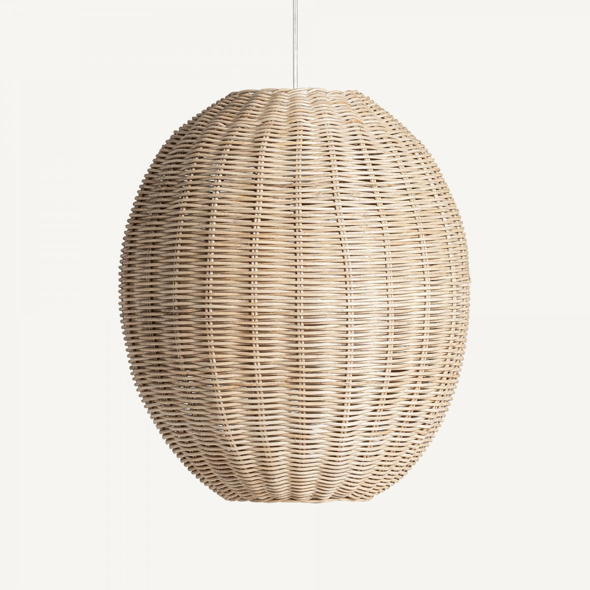 La Lámpara colgante en ratán Tekax, de forma redonda y color marrón natural, cuelga de un cable blanco sobre un fondo blanco, aportando un aire boho chic a cualquier espacio.