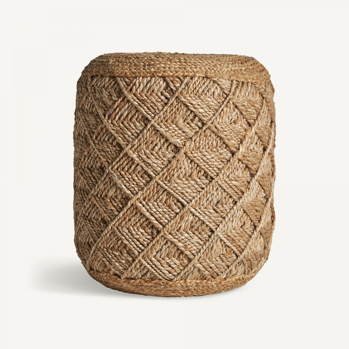 El Puff redondo de yute trenzado Elgin presenta un patrón de diamantes elaborado con fibras naturales, que exuda un encanto de estilo vintage, colocado elegantemente sobre un fondo blanco liso.