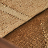 Primer plano de tela texturizada marrón y beige con costuras y fibras visibles, evocando un diseño vintage que recuerda a un sillón de madera y yute Elgin.