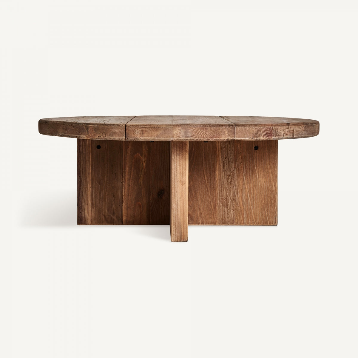 Vista frontal de la Mesa auxiliar en madera reciclada Crissey, una mesa de centro ovalada de madera que presenta una tapa segmentada y una base resistente, sobre un fondo liso.