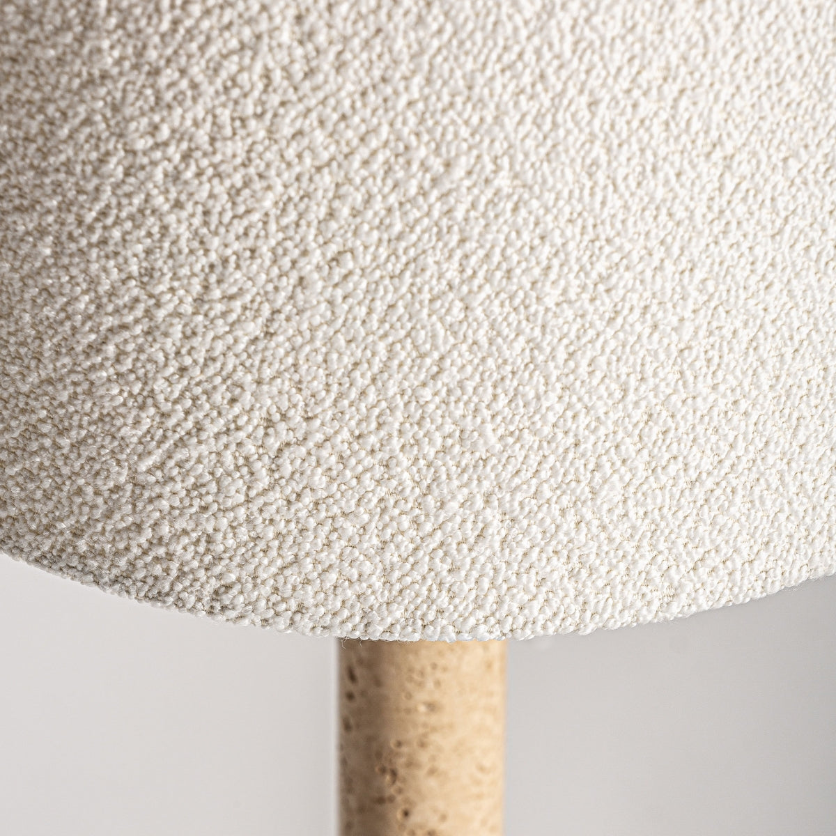 Primer plano de la pantalla texturizada de color blanquecino y la base cilíndrica de la Lámpara de mesa en mármol y metal Artecia, ideal para agregar decoración exclusiva y estilo art deco a tu espacio.