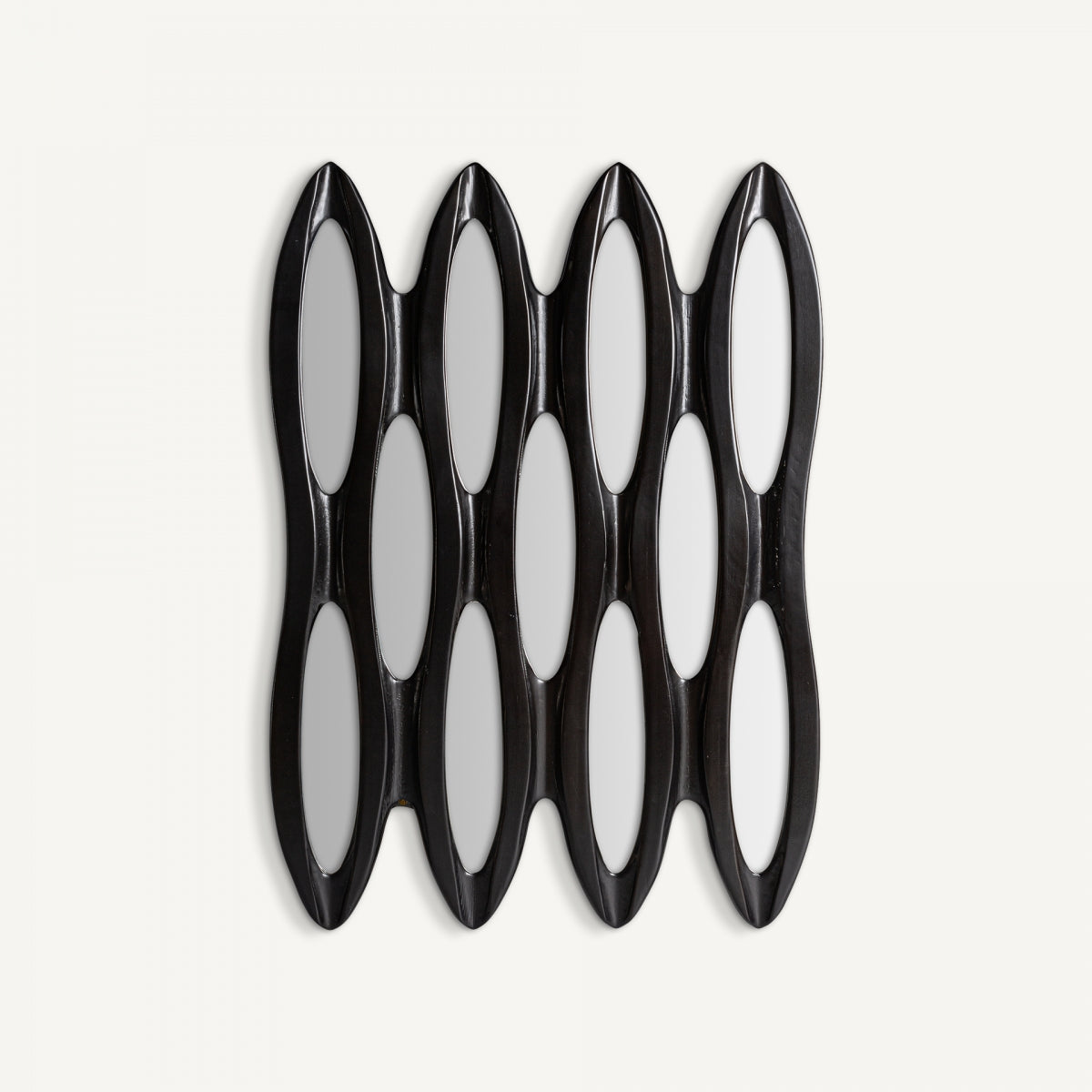 El espejo decorativo de pared en madera negra (73 x 101 cm) Riley presenta seis paneles de espejo ovalados alargados dispuestos verticalmente en un marco negro brillante: un acento contemporáneo que agrega exclusividad y encanto artesanal a cualquier espacio.
