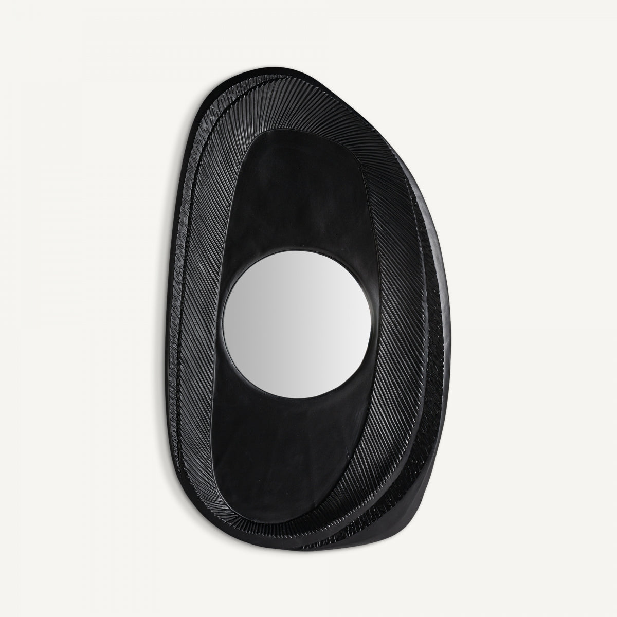 El espejo de pared Riley (97x57 cm) presenta una forma irregular, un marco de resina negra y hierro, una superficie texturizada y un centro reflectante circular, todo sobre un fondo blanco liso.
