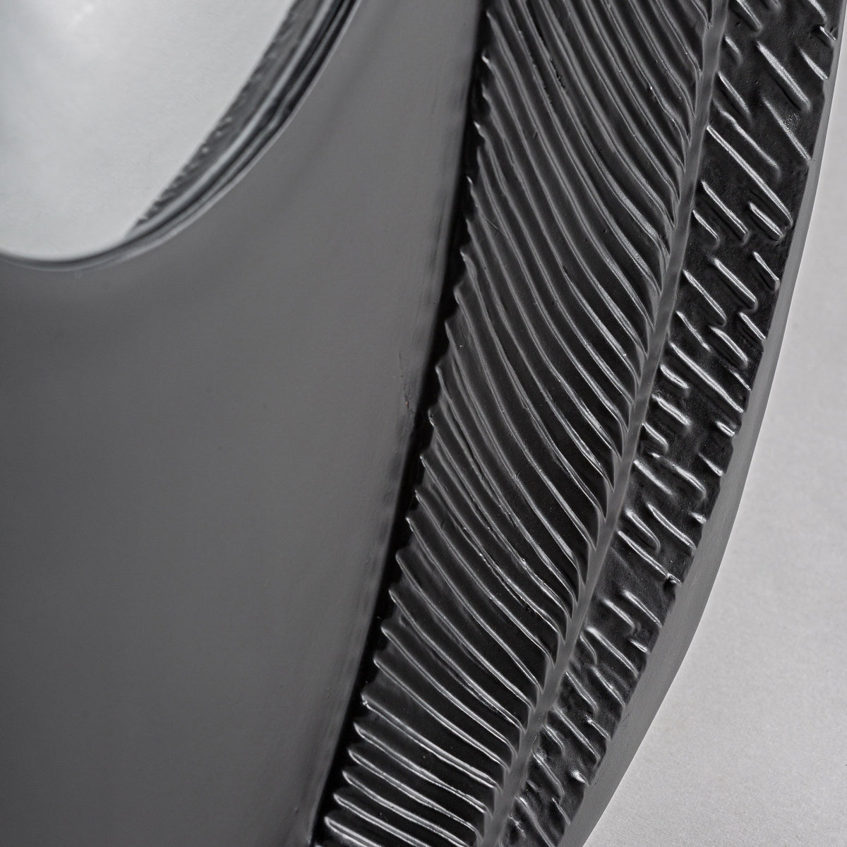 Primer plano del Espejo de pared en resina negra y hierro (97x57 cm) Riley, con elegantes detalles de resina negra y un diseño moderno sobre una superficie gris claro.