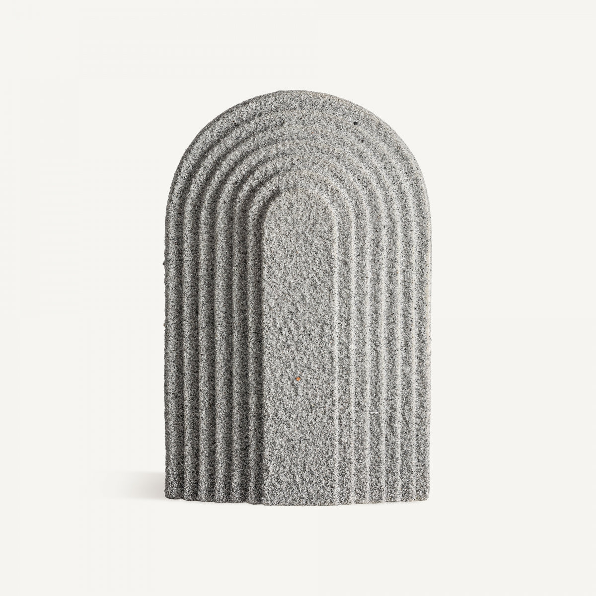 Una Figura decorativa de resina rugosa Tirso, de color gris y diseño arqueado con surcos uniformes, se exhibe erguida sobre un fondo blanco, aportando elegancia y estilo a cualquier espacio.