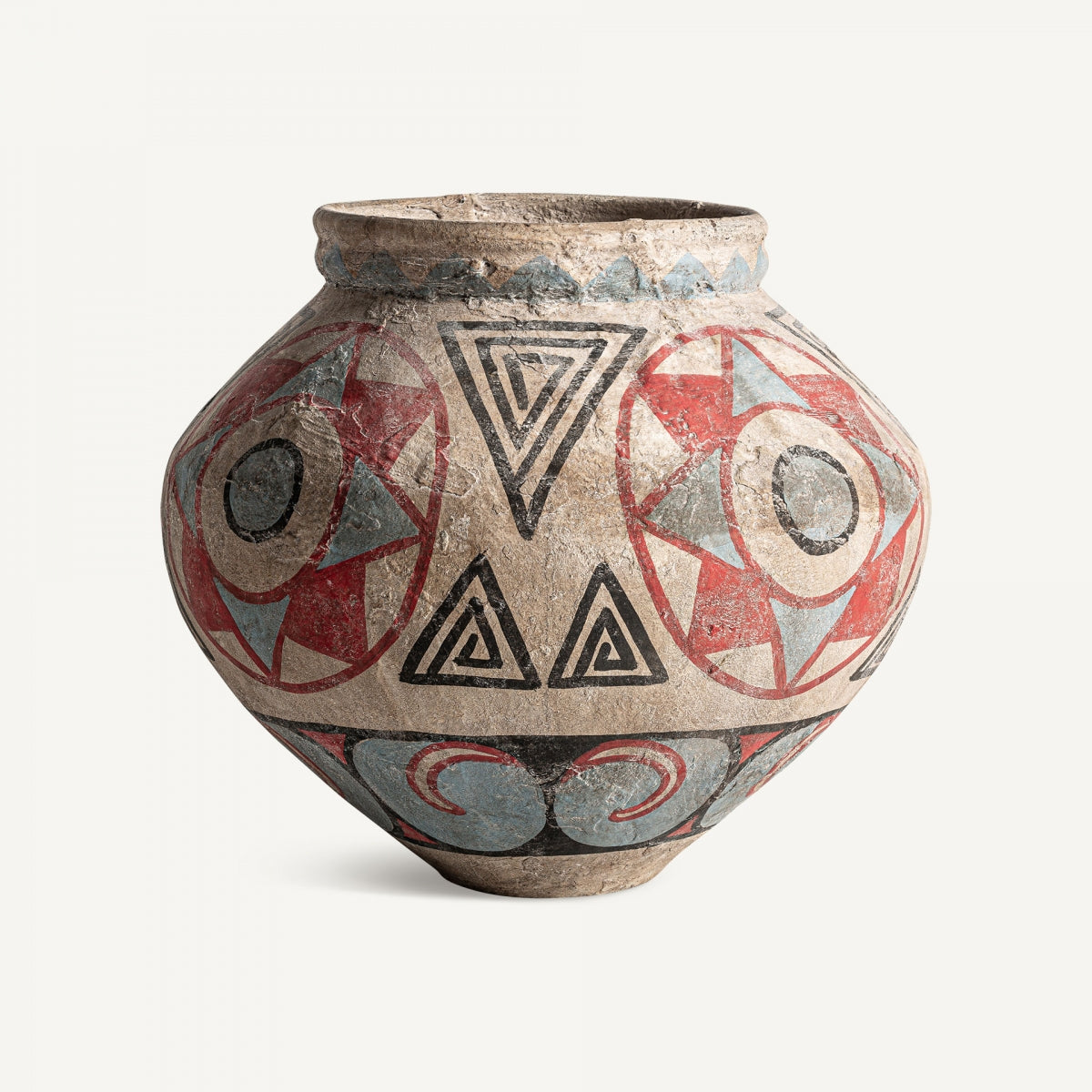 El Jarrón en terracota multicolor Heneo es una pieza de cuerpo ancho con patrones geométricos rojos, negros y azules que incluyen triángulos y círculos, reflejando un diseño etnológico único.