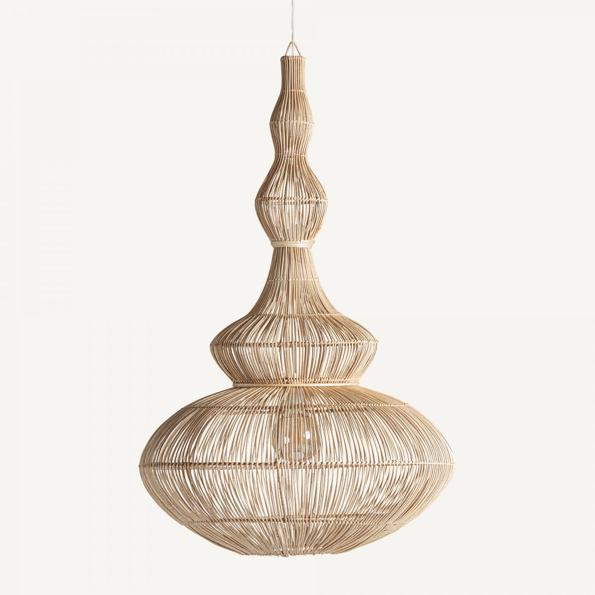 La lámpara colgante en ratán boho Satu, con su diseño de mimbre, base redondeada y parte superior cónica, cuelga elegantemente de un solo cordón sobre un fondo liso, agregando encanto a la decoración de su hogar.