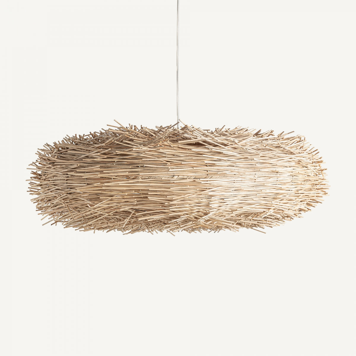 La Lámpara colgante en ratán Boho Nest presenta una forma ovalada elaborada con un material similar a la paja, mostrando un diseño artesanal. Es ideal para introducir la decoración bohemia en cualquier espacio.