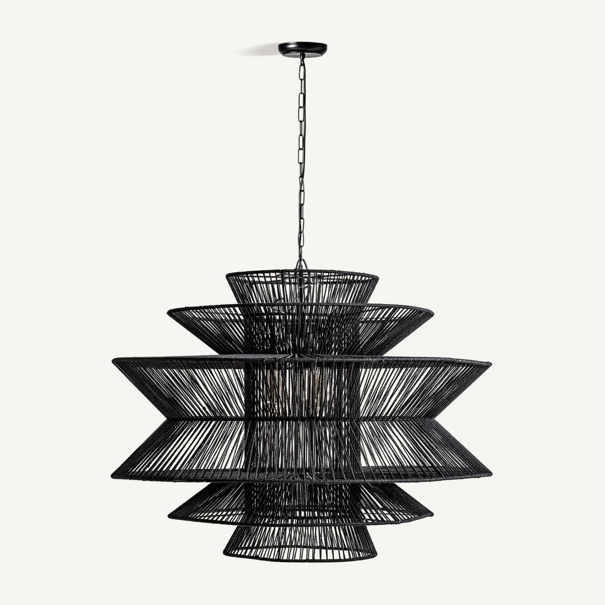 La lámpara colgante de metal y algodón Boho-Noir, con una estructura de alambre negra y un diseño geométrico moderno escalonado, cuelga elegantemente de una cadena sobre un fondo blanco liso.