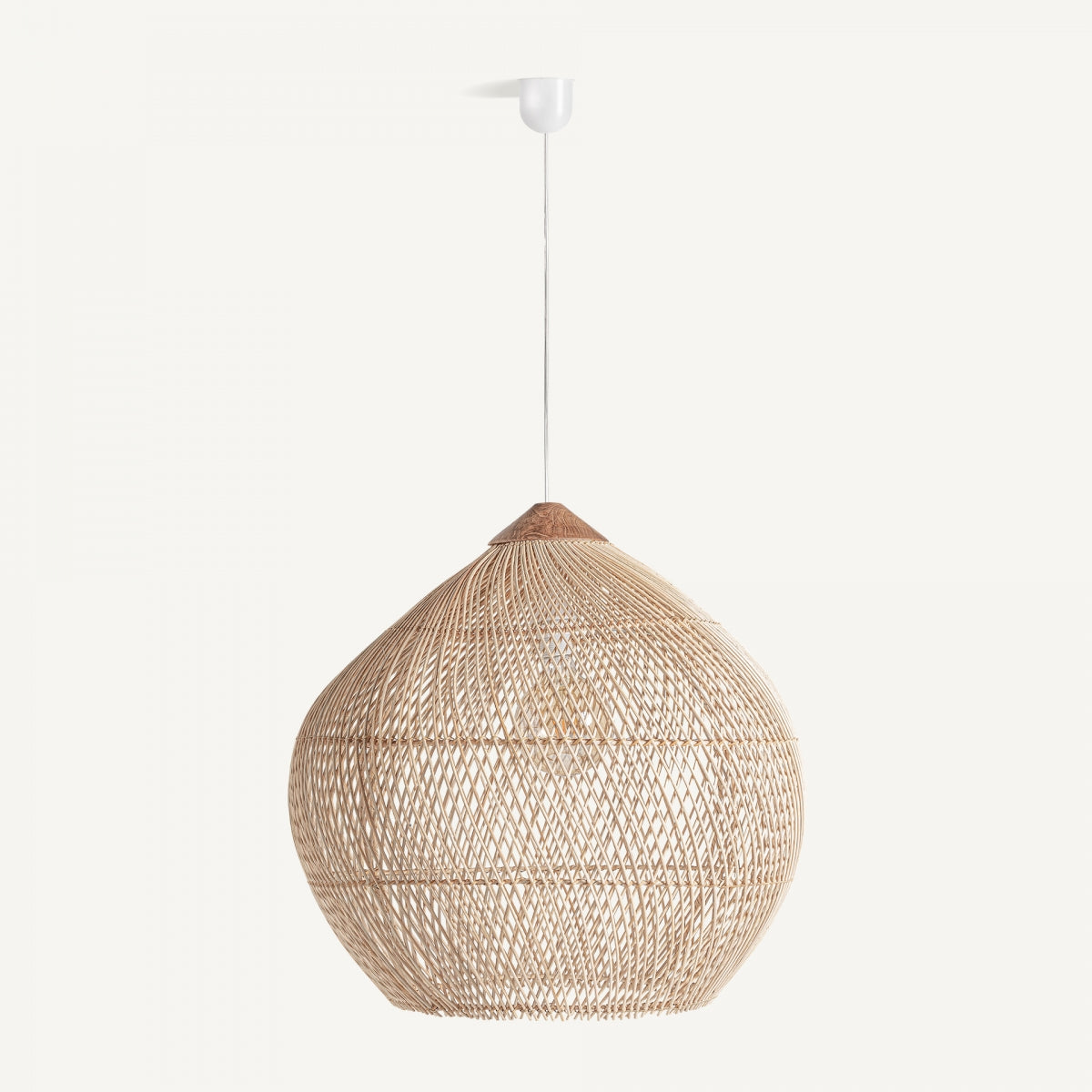 La lámpara colgante en ratán Boho-Z, con su forma redondeada, cuelga de un techo blanco, infundiendo al espacio un diseño bohemio.
